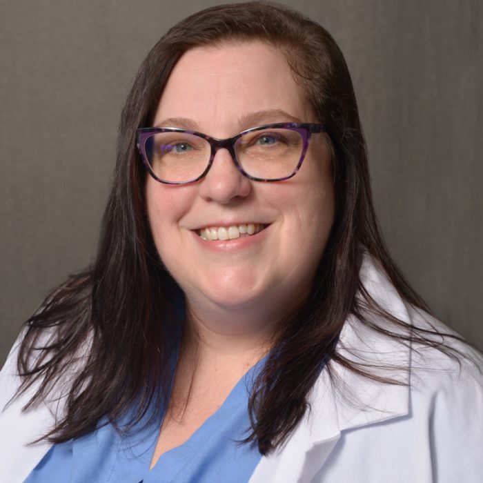 photo of female in white medical coat with shoulder length brown hair
