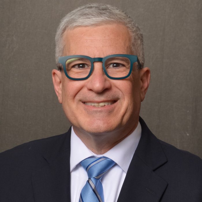 man wearing glasses and blue suit and neck tie