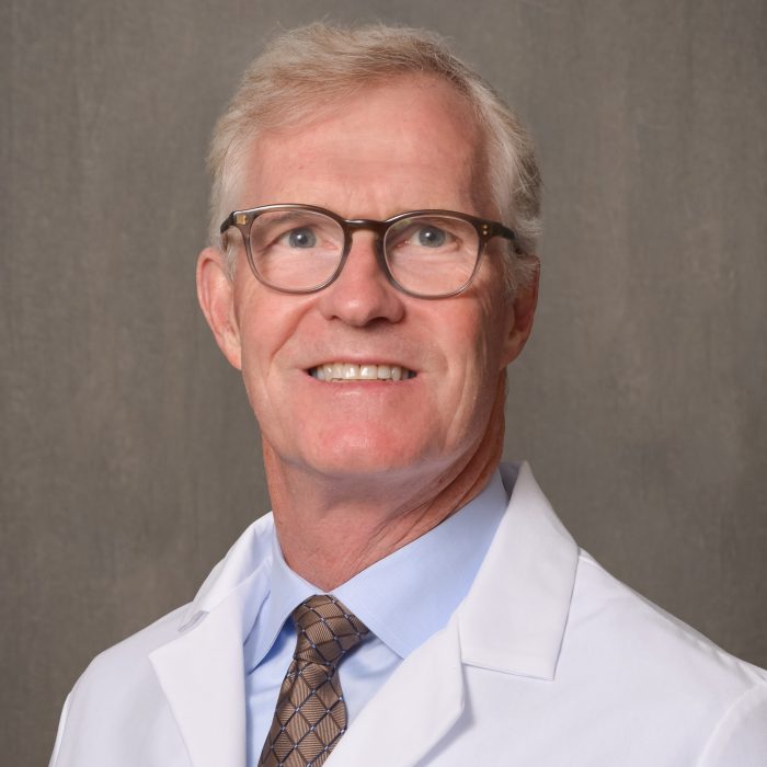 male physician with light hair and glasses
