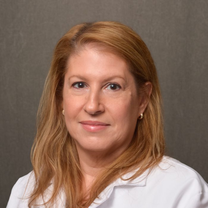 female physician with shoulder length strawberry blonde hair in white lab coat