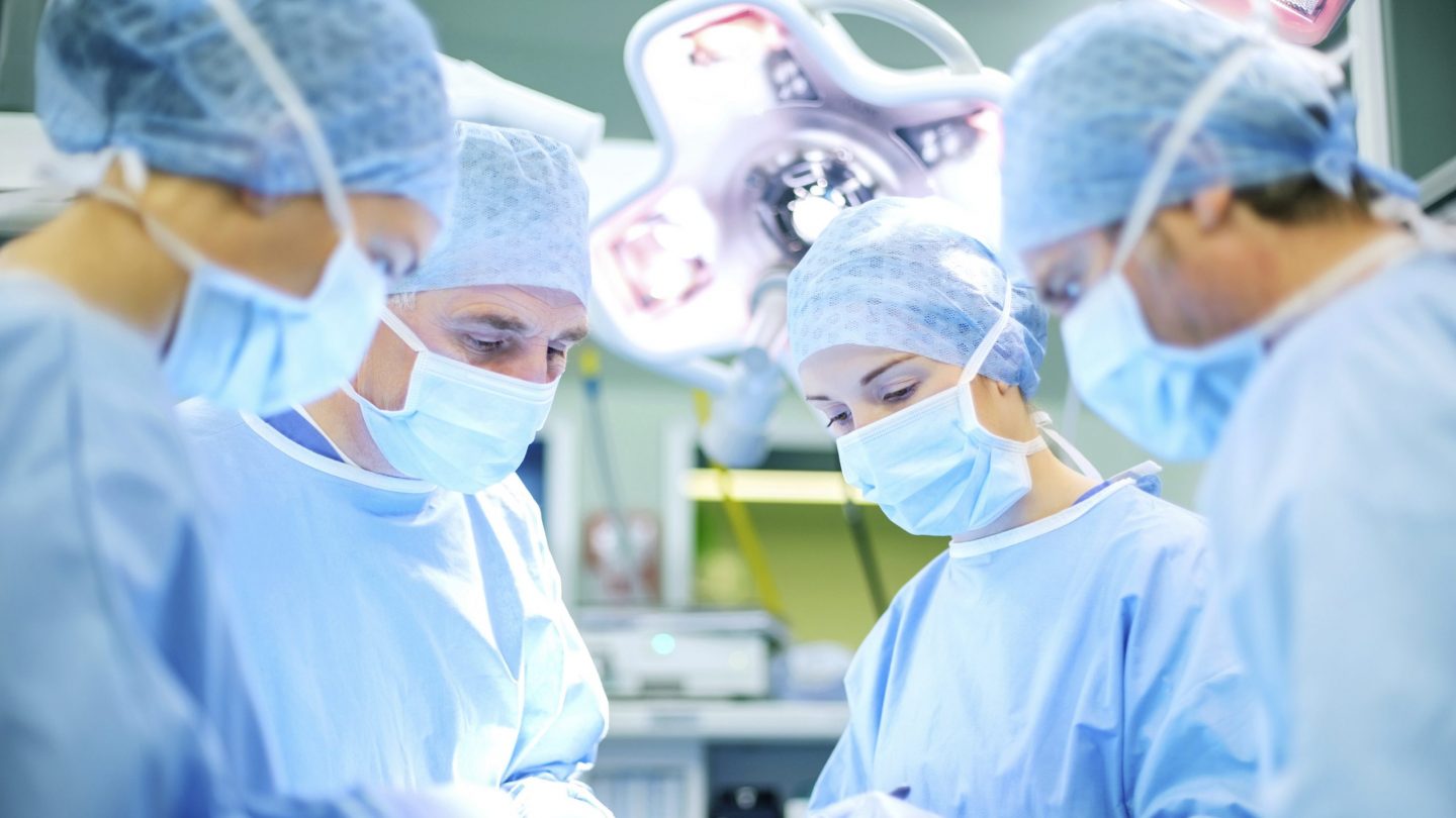 Surgeons Operating Patient In Hospital Theater