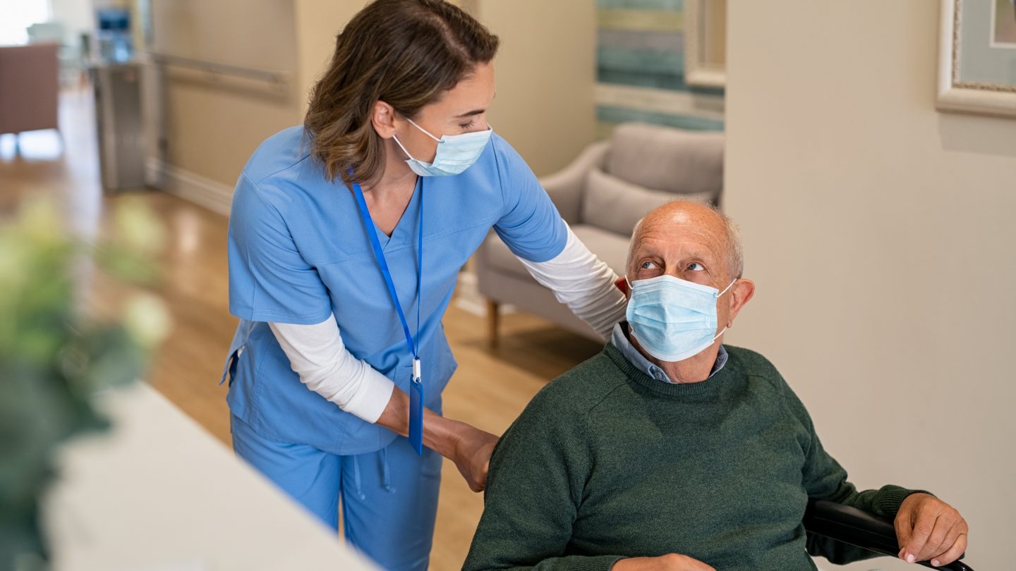 Nurse helping man in wheelchair