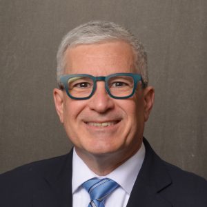 man wearing glasses in dark suit and tie