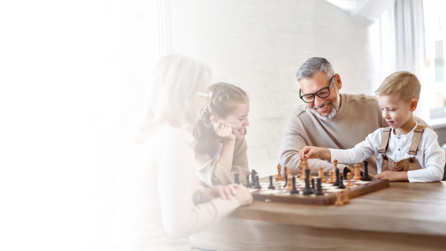 Father playing chess with son